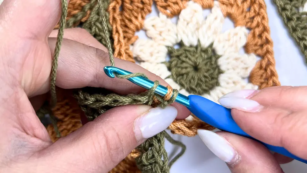 Yarn over and pull through both loops to complete the slip stitch join between the granny squares.