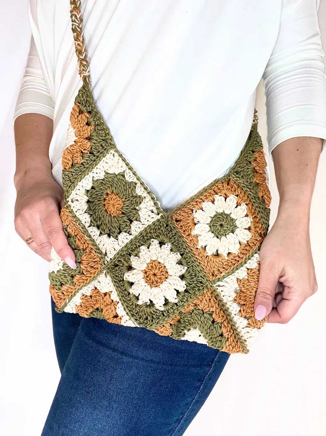 Person modeling the Meadow Daisy Bag over their shoulder, highlighting the bag’s size, stitch texture, and how it looks when worn.