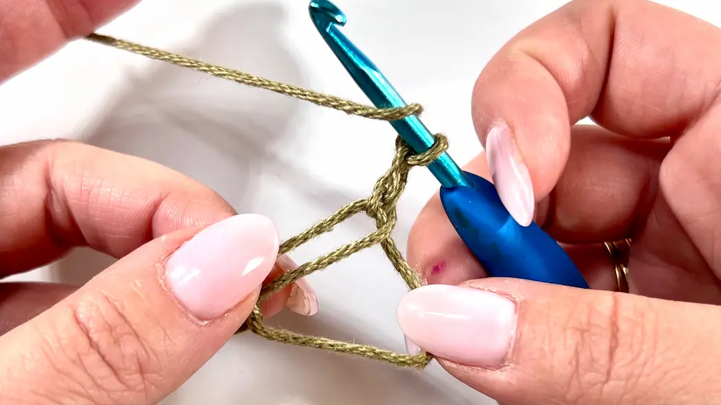 Forming the centre ring for the Daisy Granny Square with a crochet hook.