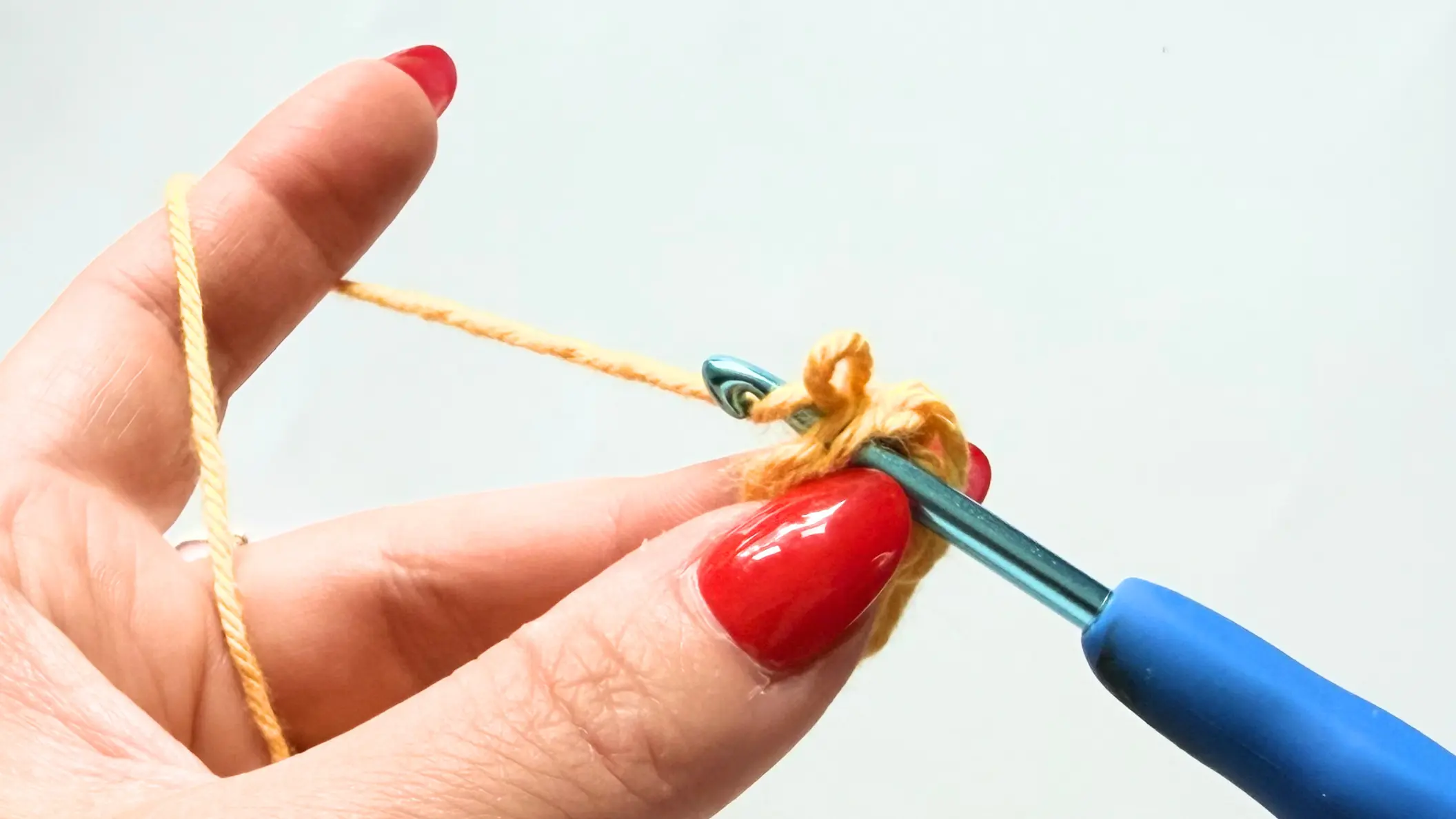 Removing the hook and inserting it through the first Single Crochet to begin the Invisible Join.