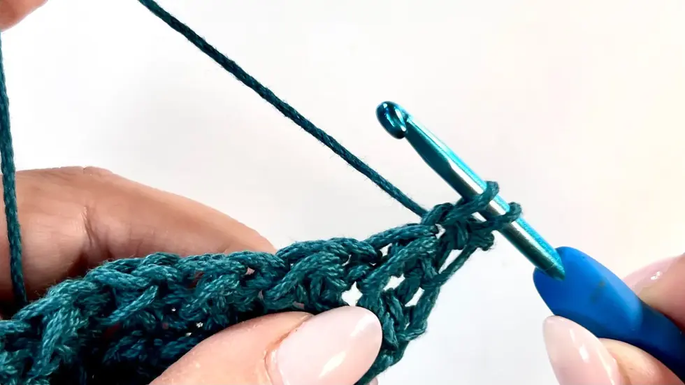 First stitch of a decrease row in the C2C Even Moss Stitch; working directly into the first stitch to start shaping the edge without increasing.