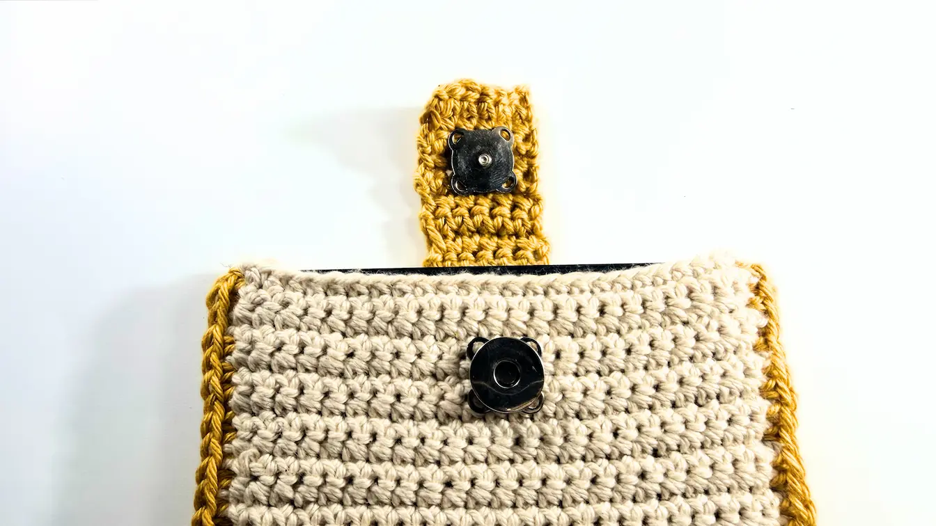 Magnetic button closure attached to The Cozy Reader Sleeve crochet pattern.
