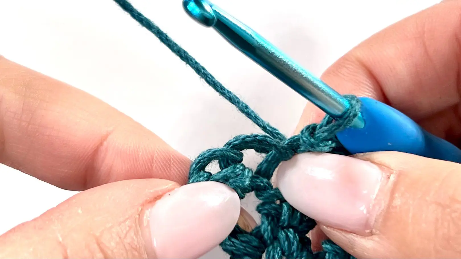 Starting a decrease on the short side of the rectangle in C2C Even Moss Stitch; hook is inserted into the third-to-last stitch, where the decrease begins once two stitches remain at the end of the row.