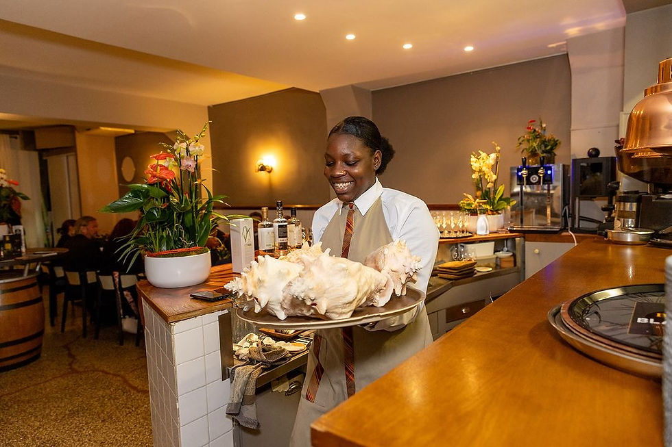 Chic Caribbean Waitress serving quality dish at Le Riche restaurant, Paris