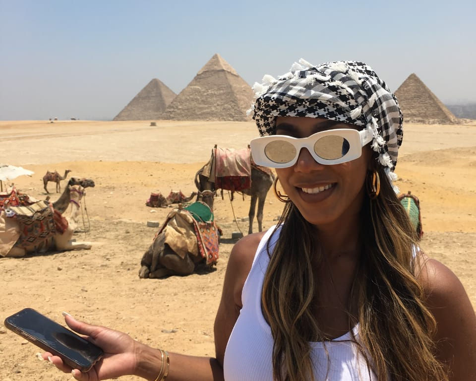 Woman posing next to the pyramids of Giza , Egypt