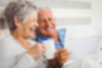 Smiling older couple read a newsletter together. Donor Newsletter