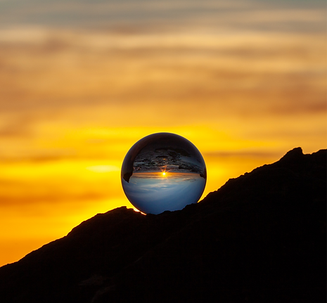clear glass ball on black mountain during sunset
