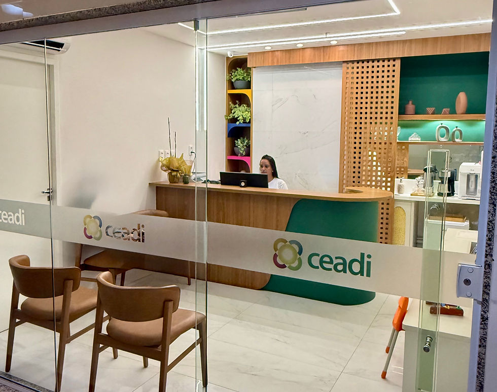 Recepção moderna com mulher atrás do balcão, cadeiras marrons e vidro com logo Ceadi; ambiente claro e organizado.