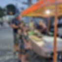 western family with kids ordering local Thai food at a street market in Thailand during the evening