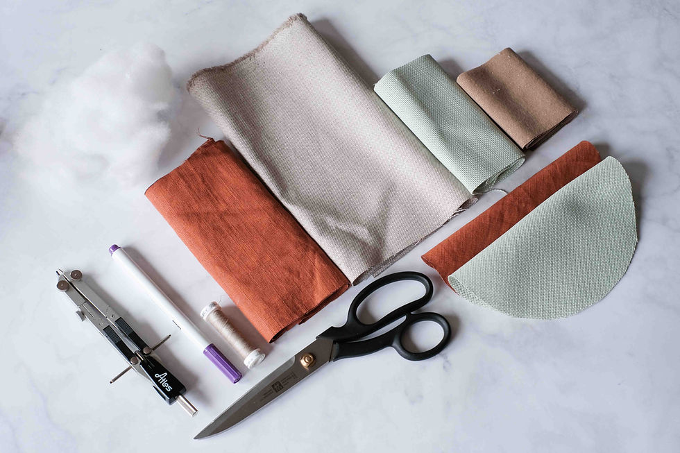 Aterial, welches man braucht, um ein rundes Kissen zu nähen: Stoff, Stoffschere, Faden, Füllwatte, Zirkel, Stifte