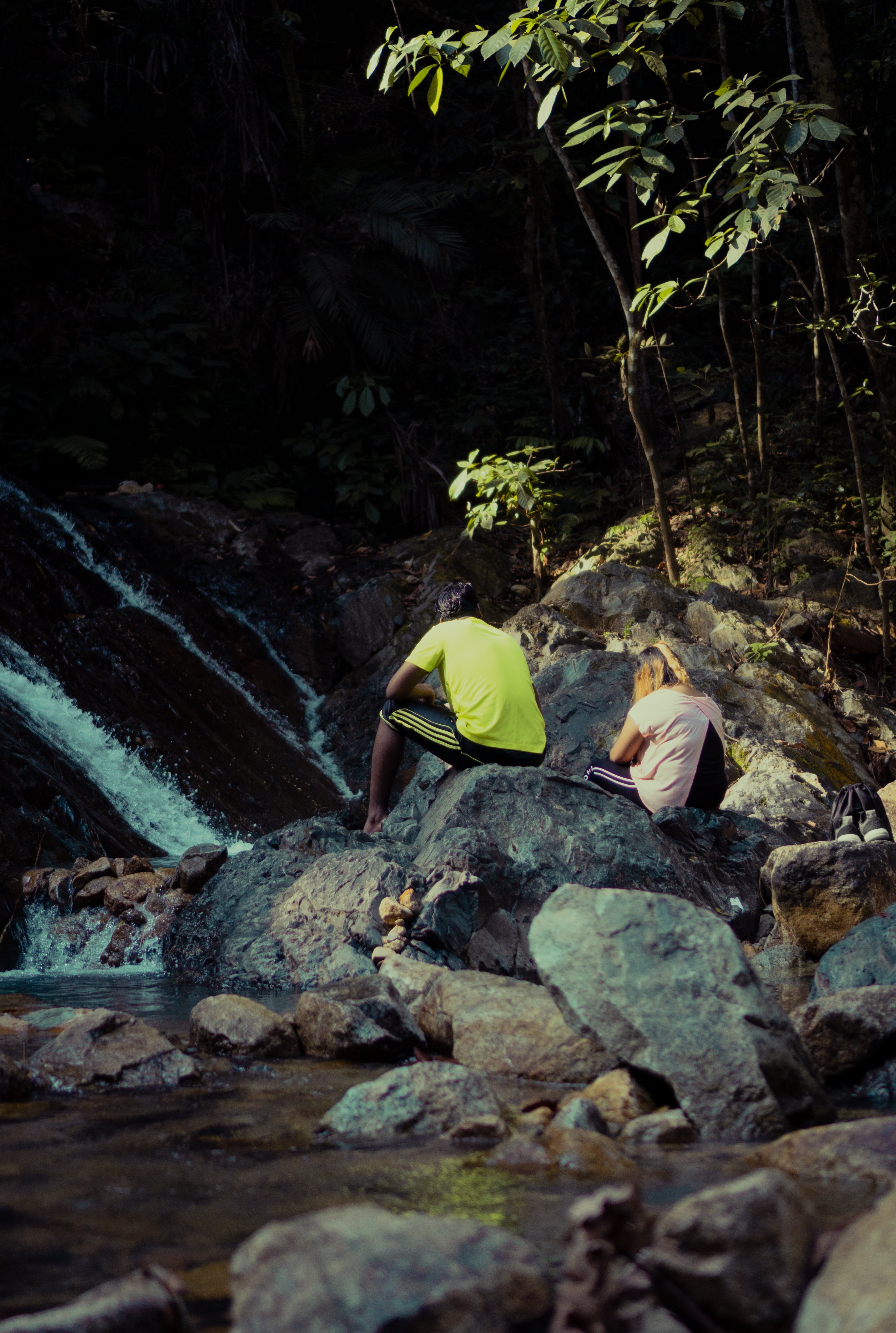 A couple sitting by the waterfall in Gunung Pulai at Johor