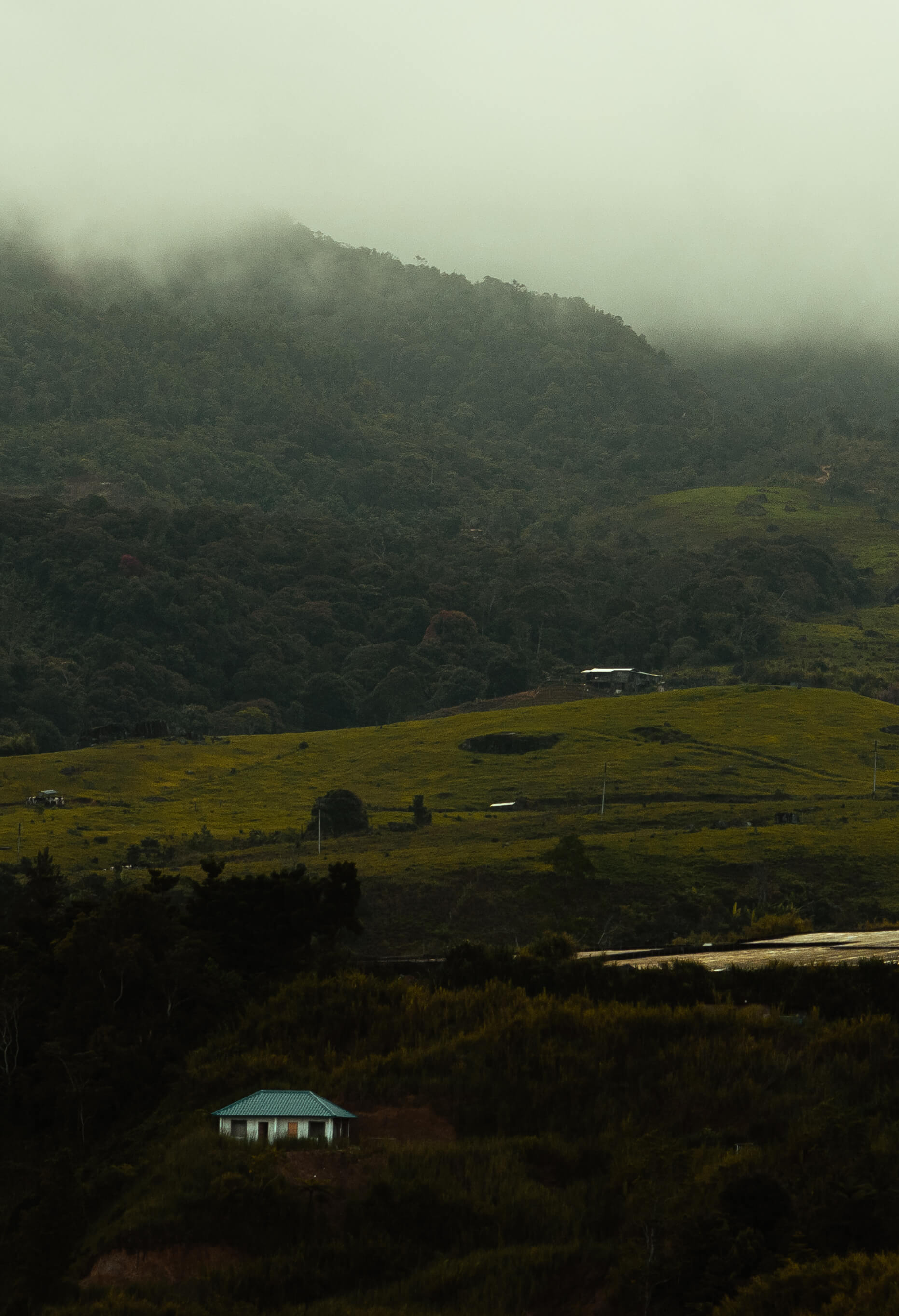 Farm and houses beside the mountain with thick clouds