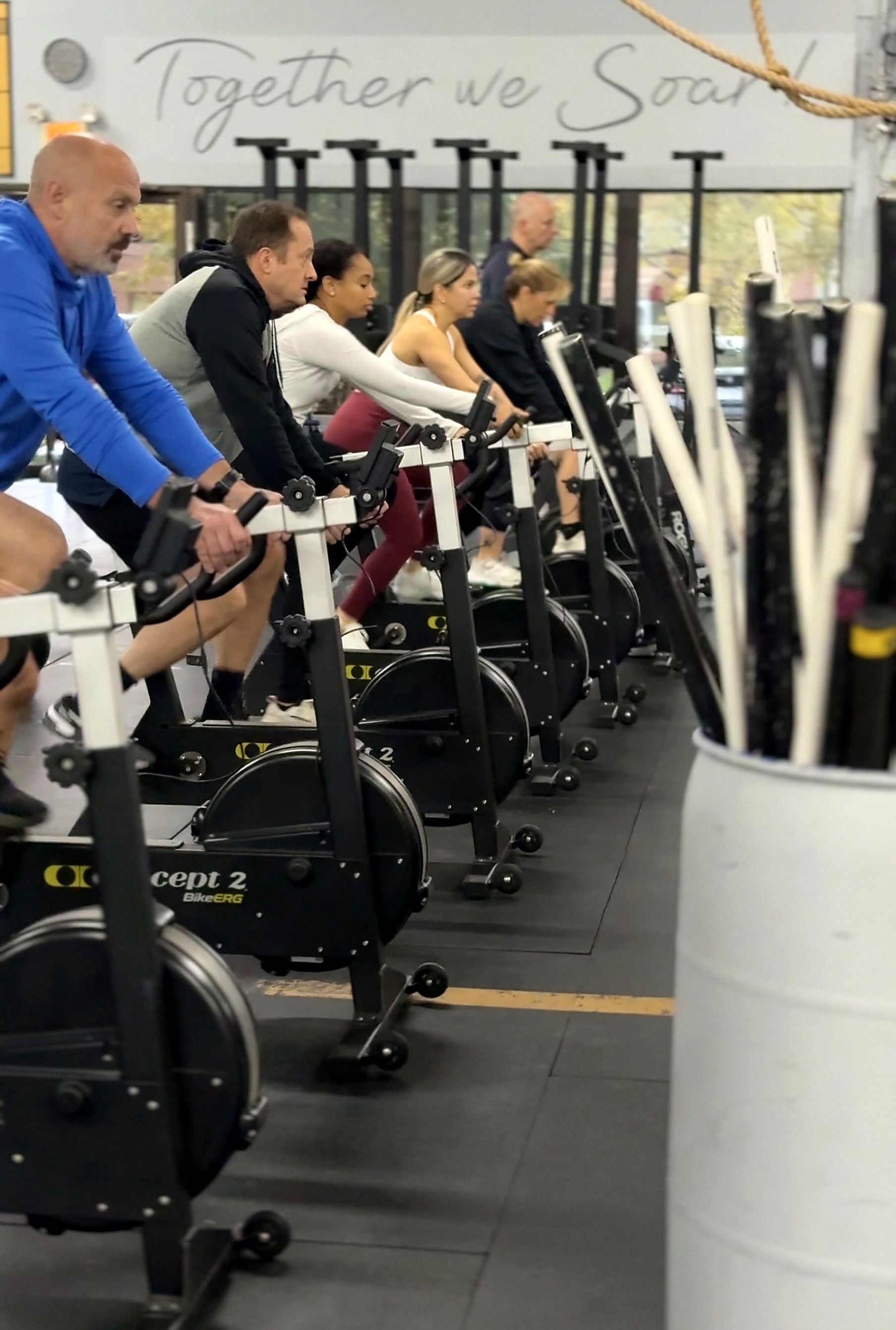 Cardinal CrossFit members riding BikeErgs during a group class