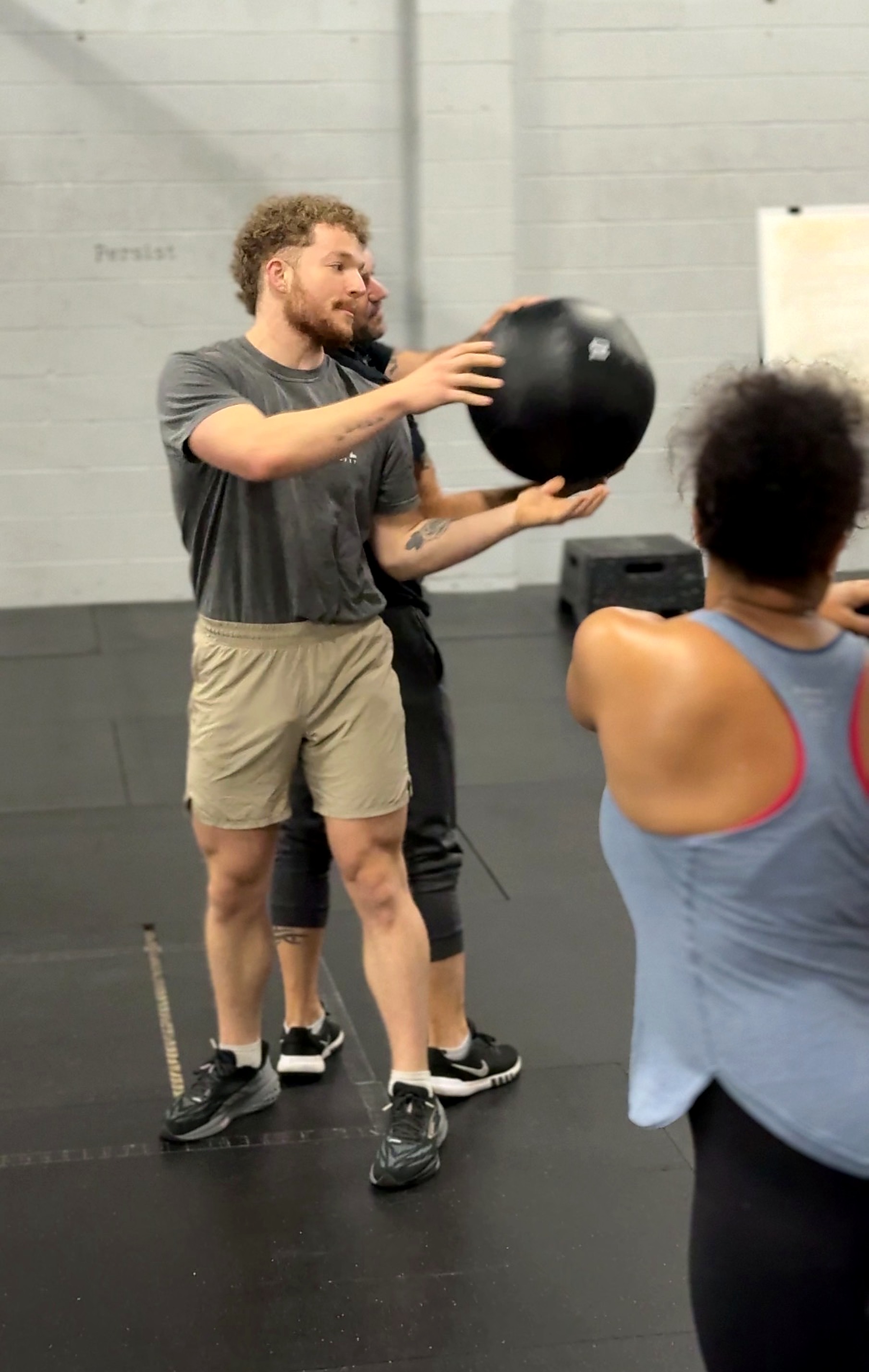 Cardinal CrossFit coach demonstrating a medicine ball movement