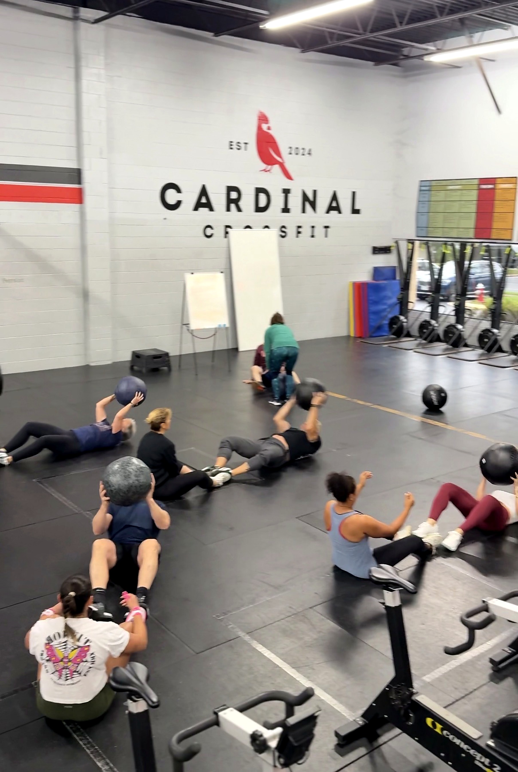 Cardinal CrossFit members practicing medicine ball movements in a group class
