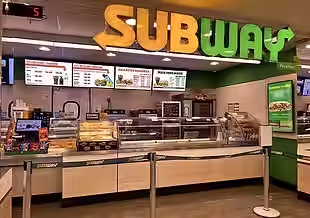 Subway restaurant counter with digital menu boards above the service line