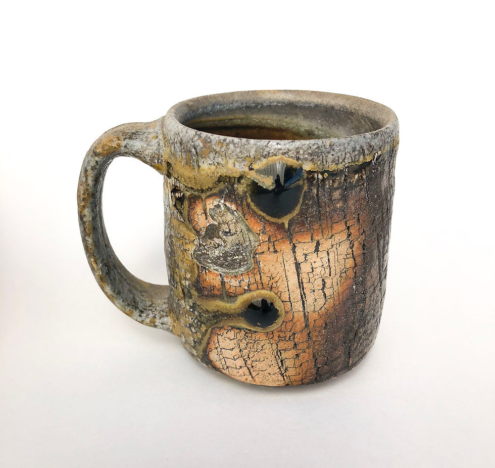 Handcrafted and wood fired Wood Fired pottery Mug with dragon's eye glaze drips.