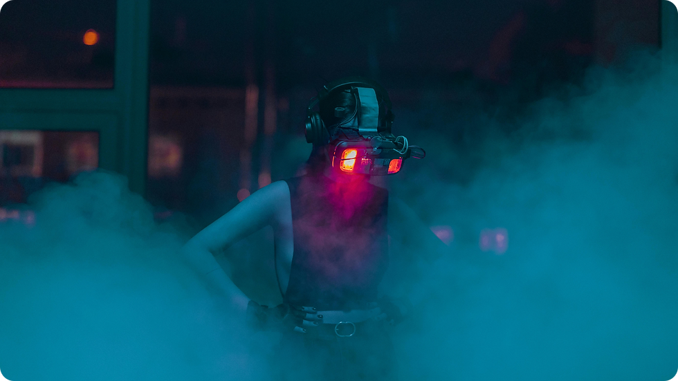 Person wearing a futuristic VR headset emits red light in a foggy room. Blue and purple hues create a mysterious, immersive atmosphere.