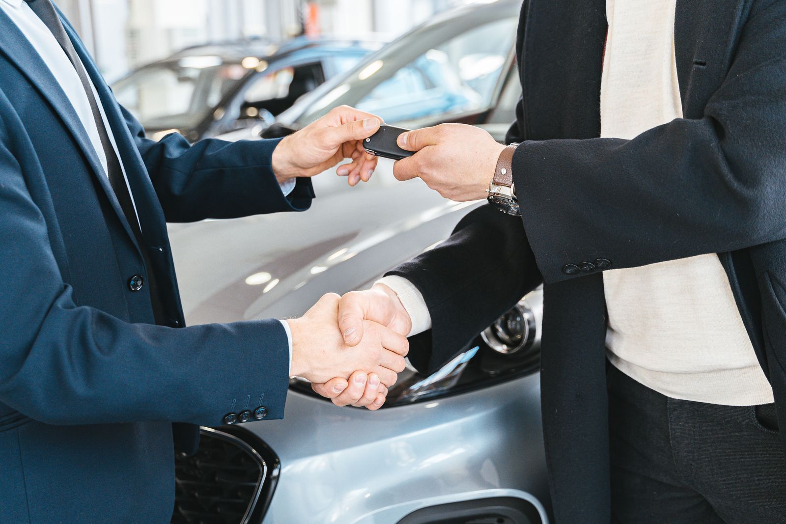 Zwei Herren bei Fahrzeugübergabe und Eintausch im Autohaus