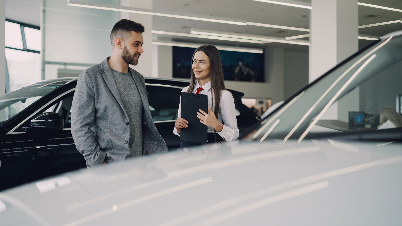 Beratungsgespräch zwischen Kunde und Verkäufer im Autohaus