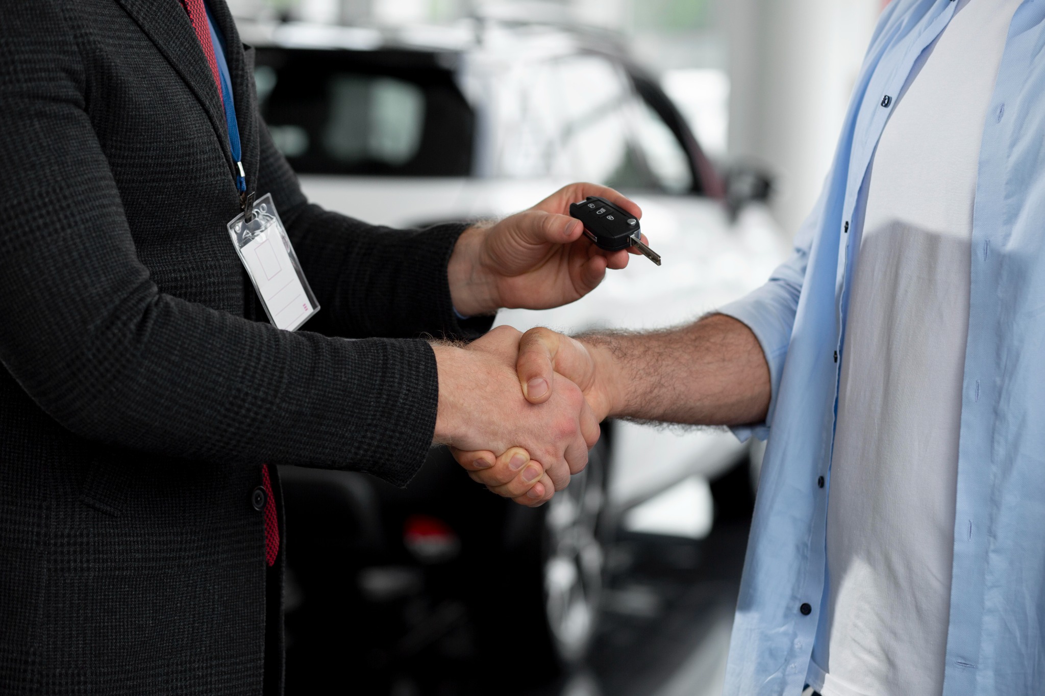 Fahrzeugübergabe mit Handschlag und Autoschlüssel