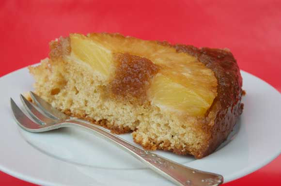 Ananascake op zijn kop op een schotel met vorkje