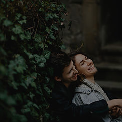 young-couple-hugging-sit-near-greenery-w
