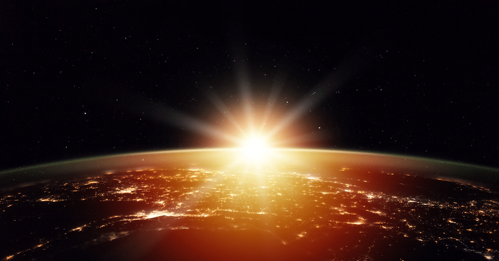 Sun rising over the earth from outer space.