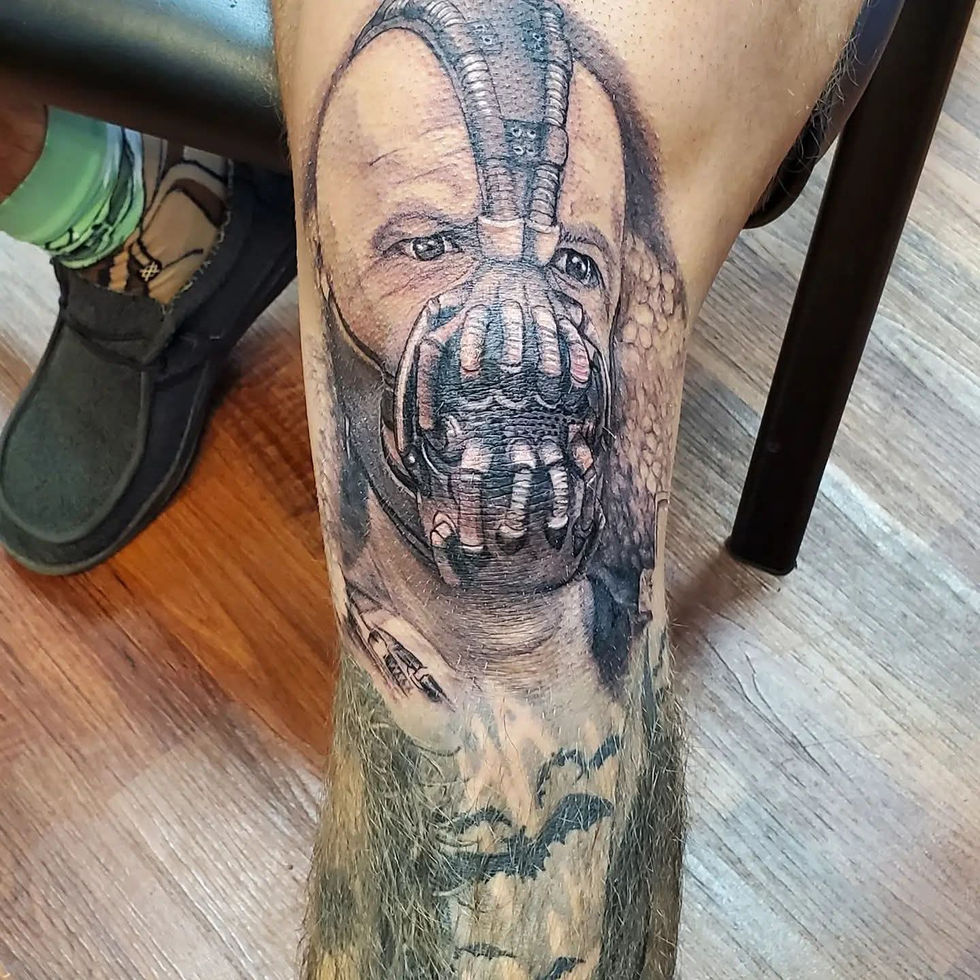 Bane tattoo on Brent's leg, intricate design with detailed imagery and shading, American Adrenaline.