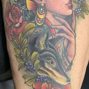 Colorful tattoo art of a woman, dog, and flowers. Lucky's tattoo work, American Adrenaline.