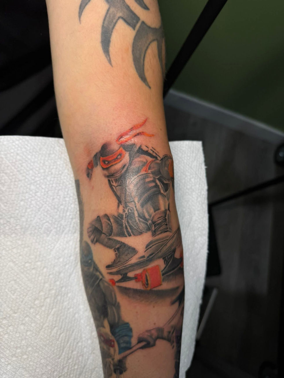 Arm tattoo of a knight with red accents, Rick Gray's Tattoo Work, American Adrenaline