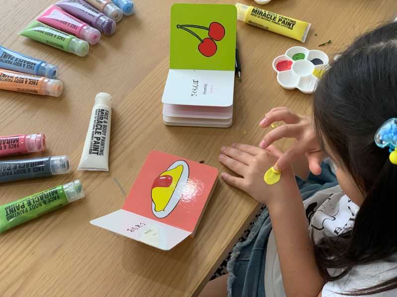 指で絵の具を取って描く子ども