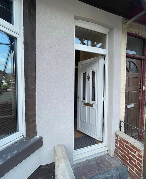 Open white uPVC front door with glazed panels, set in a rendered terraced house entrance.