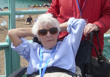 An elderly lady relaxing in a wheelchair on a beach