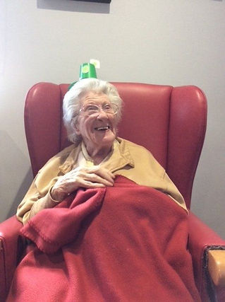 An elderly lady in a red armchair