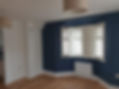 Empty room with a blue accent wall and bay window