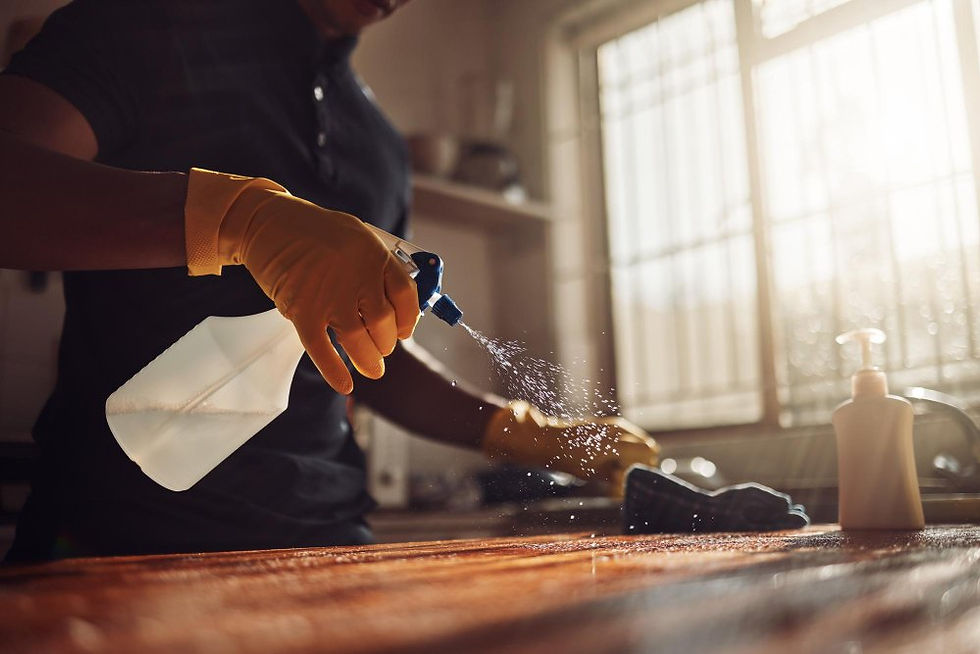 A gloved cleaner sprays a cleaning solution
