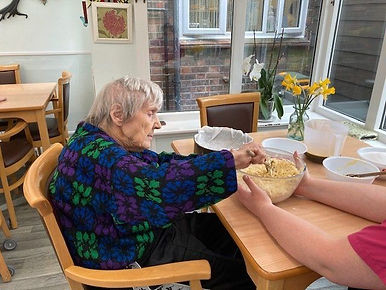 Old biddy stirring some mixture in a glass bowl