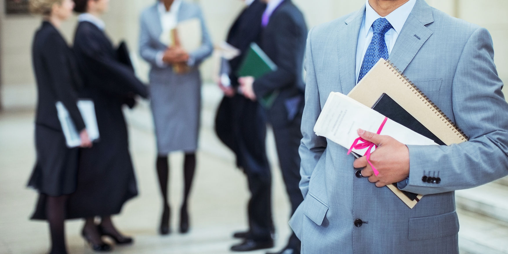A lawyer holding a document and a notebook with others
