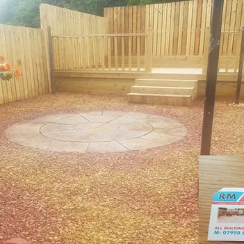 Cosy back garden with circular stone patio and gravel ground