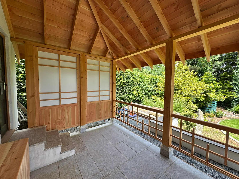 Timber-framed veranda with exposed beams overlooking woodland in Launceston