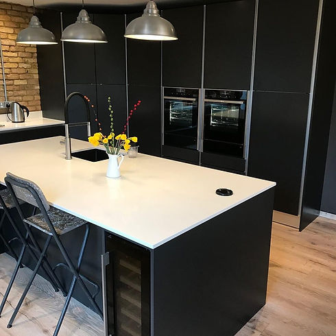 Modern kitchen with black cabinetry and two built-in ovens