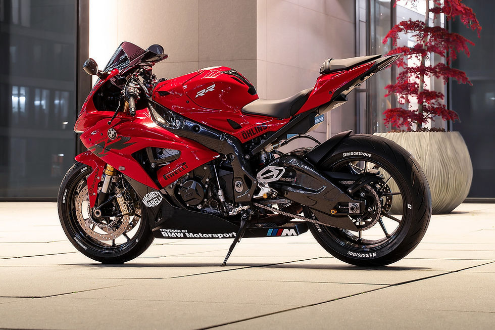 The image shows a vibrant red BMW S1000RR superbike, a high-performance track-focused motorcycle parked on a paved outdoor plaza