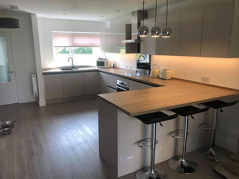 Modern kitchen with light wood flooring and L-shaped wooden countertops