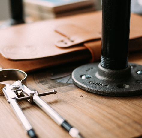 A wooden desk with a drafting compass