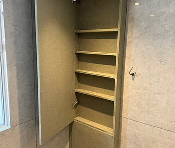 Tall wooden bookcase fitted into an alcove space