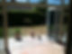 A patio with bi-fold doors leading to a garden.