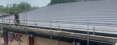 Rows of newly laid red terracotta tiles on a large commercial roof project