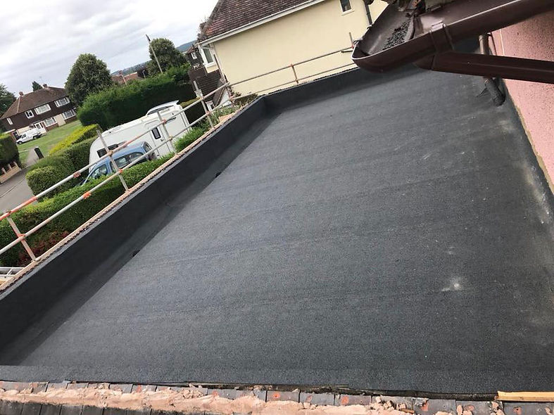 A flat roof covered with a sleek black roofing membrane, showcasing a modern and minimalist design.