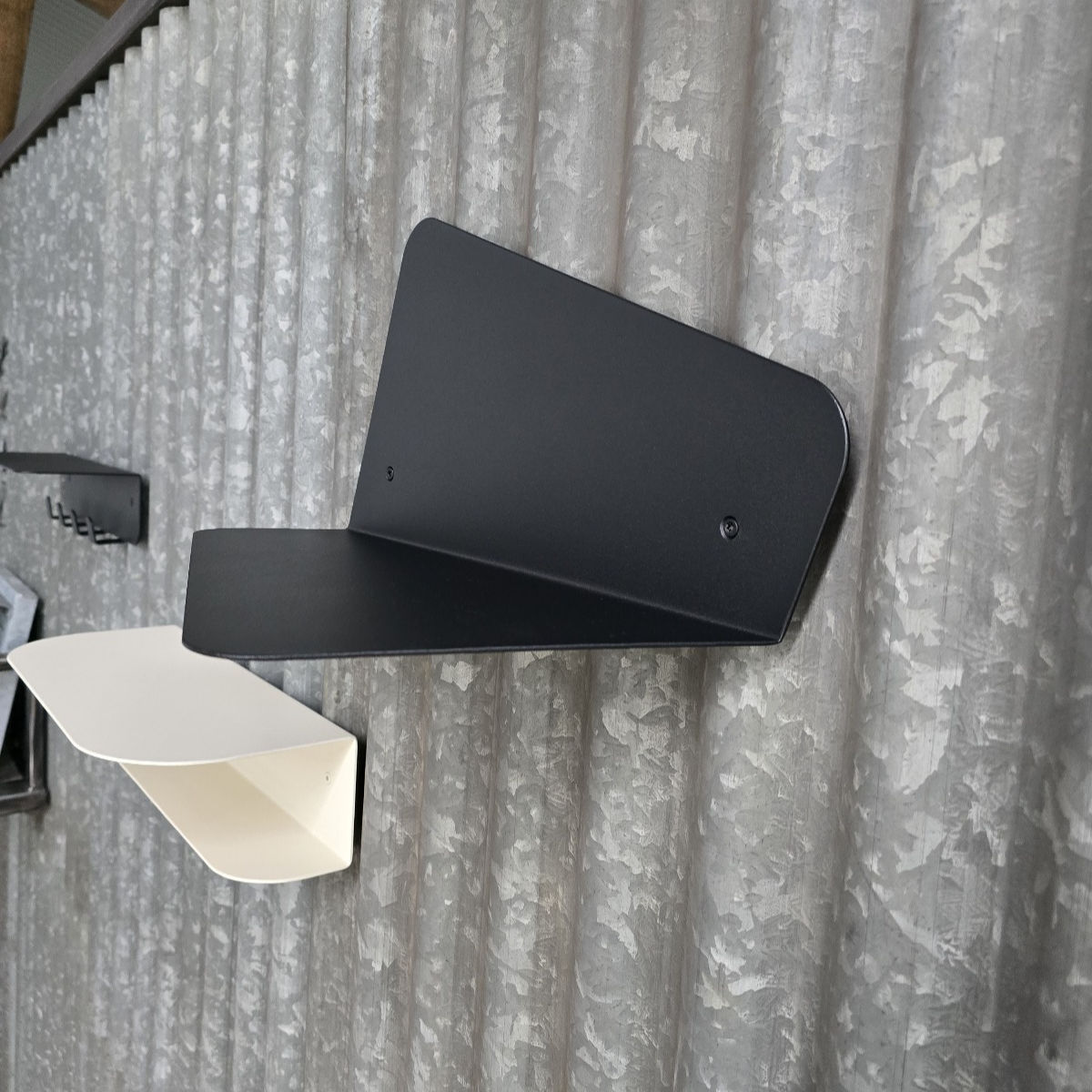 Vue de profil d’une étagère murale moderne en métal noir mat.